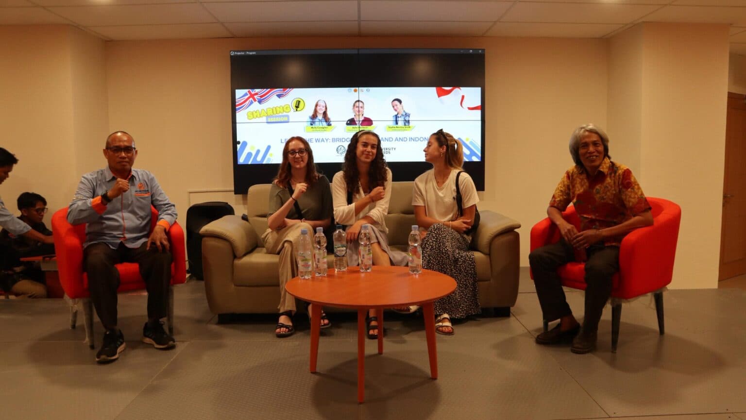 Three University of Leeds students sit with UNJA Library representatives during the sharing session